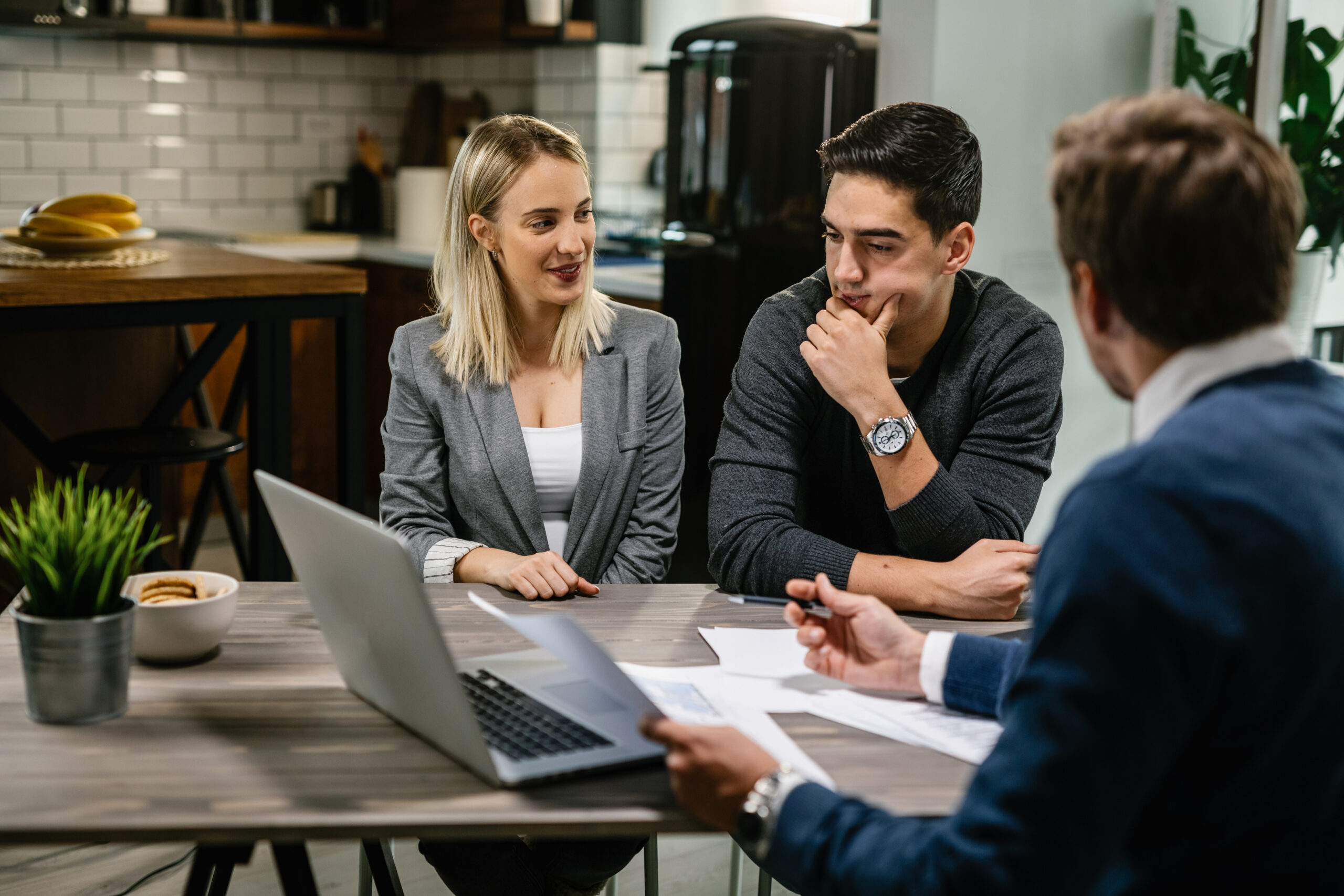 Young couple having a meeting with real estate agent at home.